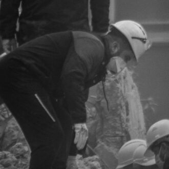 Turkey earthquake rescue workers gathered on and around debris looking through rubble for people