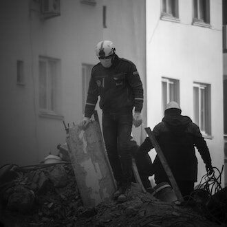 Masked rescue workers searching through rubble in Adana, Turkey, on 8 February 2023