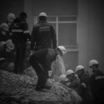 Turkey earthquake rescue workers gathered on and around debris looking through rubble for people